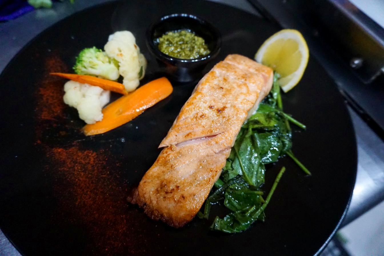 Grilled salmon steak with butter garlic or pesto sauce at Aziana
