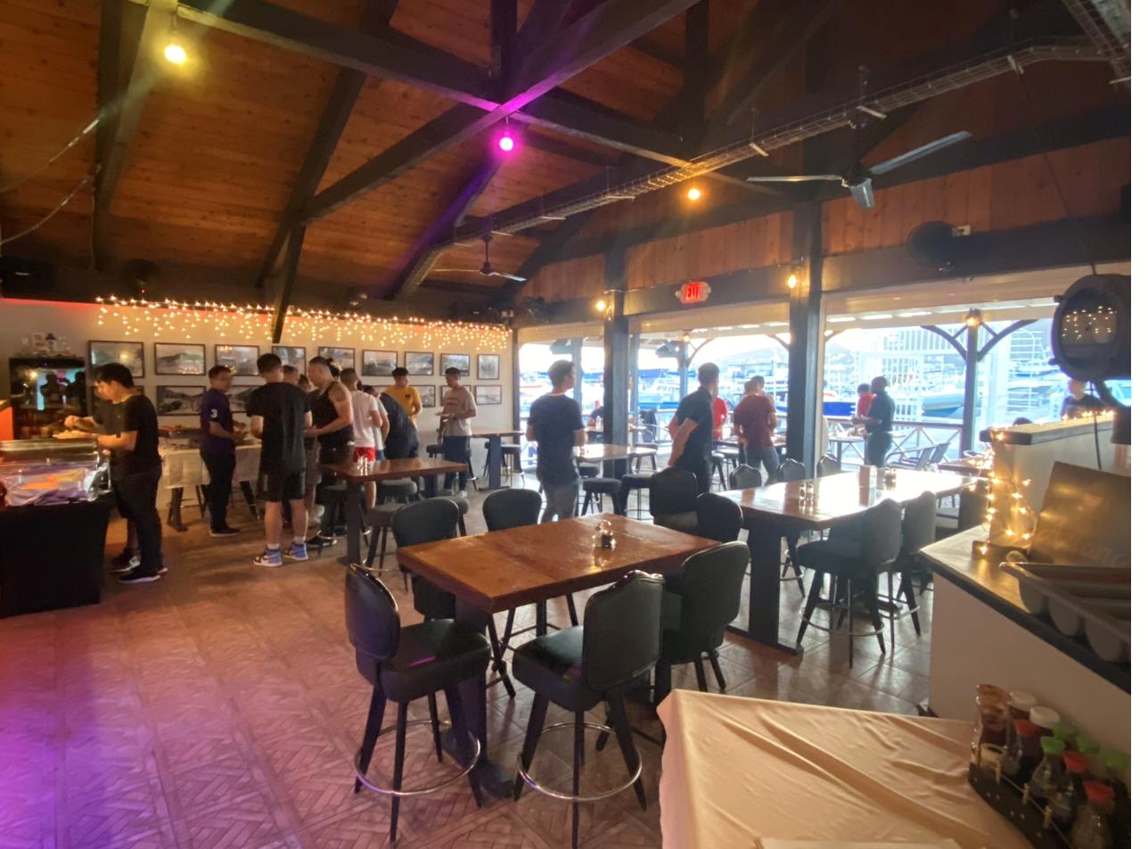 Private event indoors at Aziana with purple uplighting and marina views